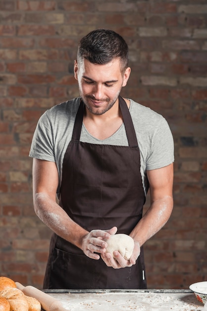 Panettiere maschio che prepara pane in forno