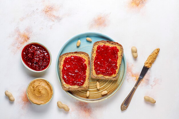 Panini al burro di arachidi o toast con marmellata di lamponi.