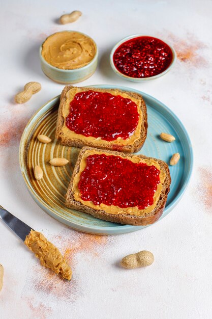 Panini al burro di arachidi o toast con marmellata di lamponi.