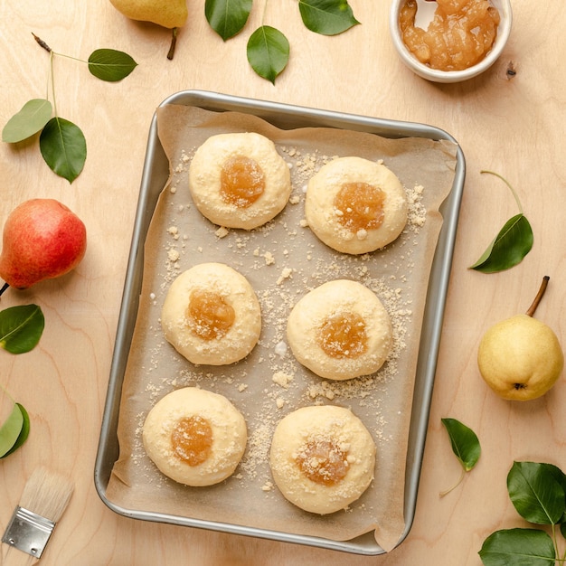 Panini crudi fatti in casa a base di pasta lievitata con marmellata e pere fresche Mini torte Ricetta di cucina su fondo di legno