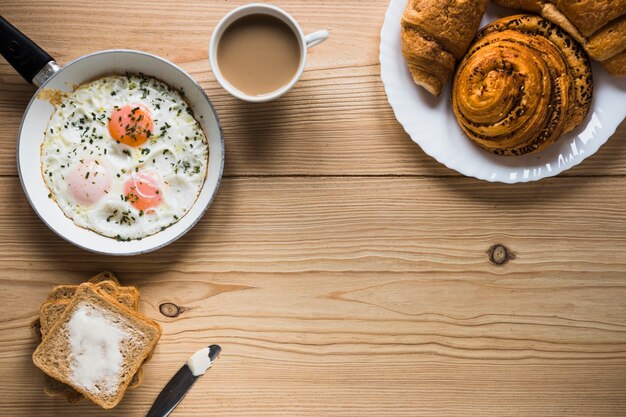 Panini e caffè vicino a uova fritte e toast