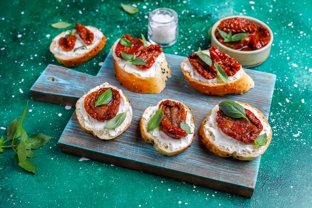 Panini italiani - bruschetta con formaggio, pomodori secchi e basilico.