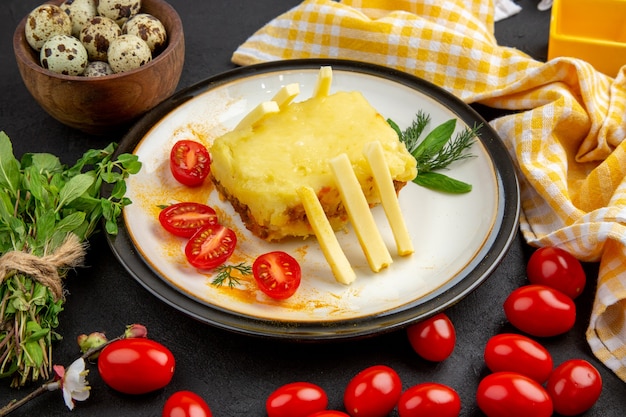 Panino al formaggio vista dal basso sul piatto giallo e bianco a quadretti asciugamano da cucina mazzo di menta ciliegia su sfondo scuro