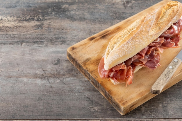 Panino al prosciutto spagnolo di serrano sulla tavola di legno