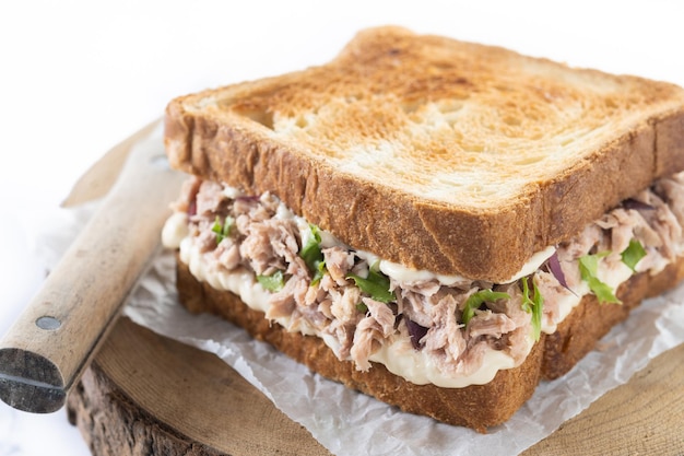 Panino al tonno con maionese e verdure isolate su sfondo bianco