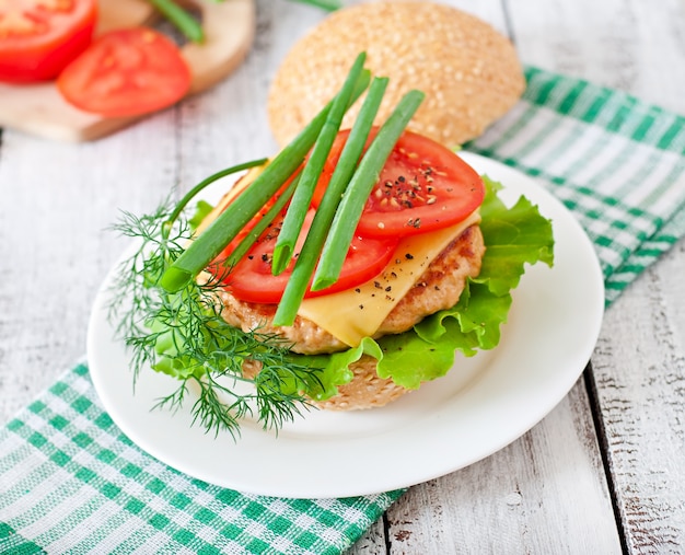 Panino con hamburger di pollo, pomodori, formaggio e lattuga