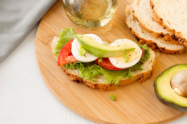 Panino dei pomodori e dell'uovo sodo sul bordo di legno