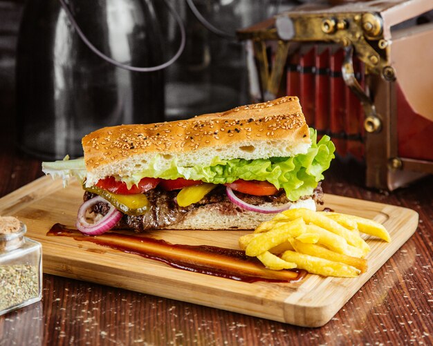 Panino di carne vista laterale con patatine fritte sul bordo