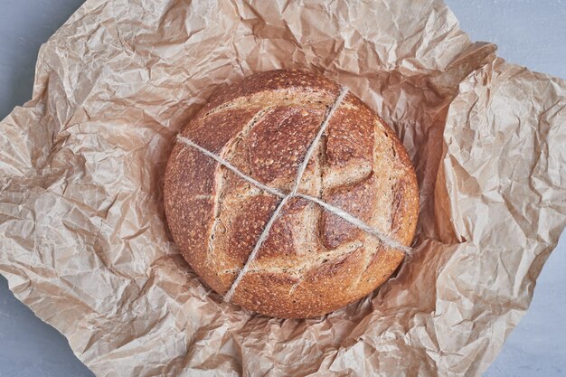 Panino di pane tondo fatto a mano su carta.