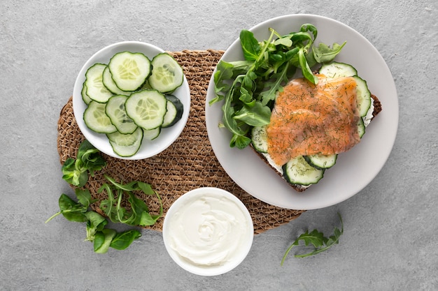 Panino piatto con cetrioli e salmone su piastra con spinaci