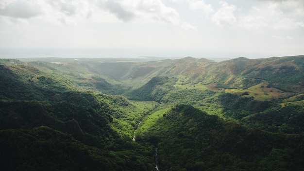 Panoramica del fiume che attraversa la foresta e le montagne catturate a Kauai, Hawaii