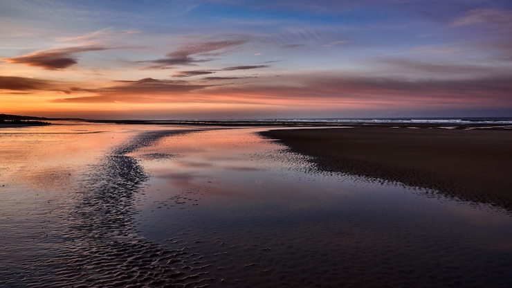 Foto gratuito panoramica della bellissima costa del mare con lo straordinario cielo nuvoloso durante l'ora d'oro
