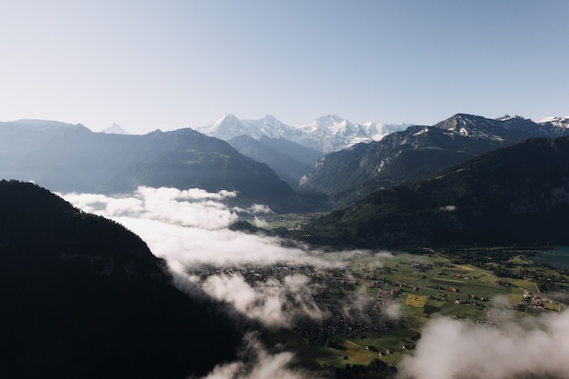 Panoramica di montagne e colline circondate da prati e nebbia verdi