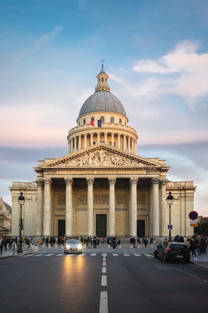 Pantheon circondato da persone sotto un cielo nuvoloso durante il tramonto a Parigi in Francia