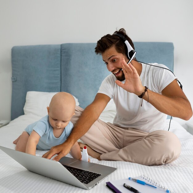 Papà che lavora da casa durante la quarantena con il bambino