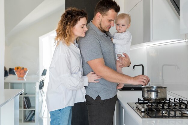 Papà che tiene bambino e cucina