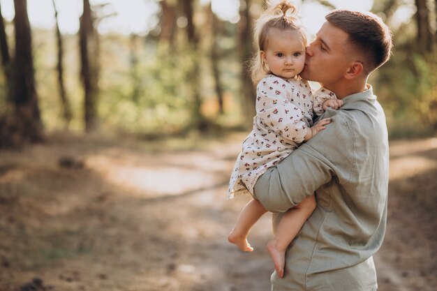 Papà con la piccola figlia che abbraccia nella foresta