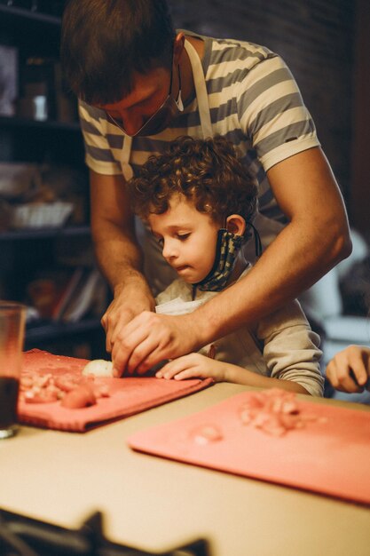 Papà e figli cucinano la pasta in una master class di gastronomia