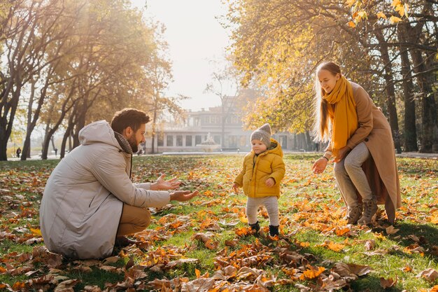 Papà felice e mamma che giocano con il bambino fuori