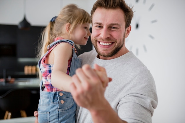 Papà sorridente che balla con la figlia