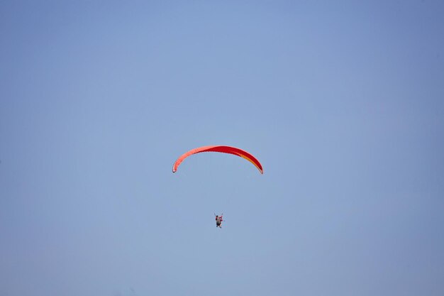 Parapendio nel cielo Parapendio che vola in una luminosa giornata di sole Bellissimo parapendio in volo su uno sfondo turchese