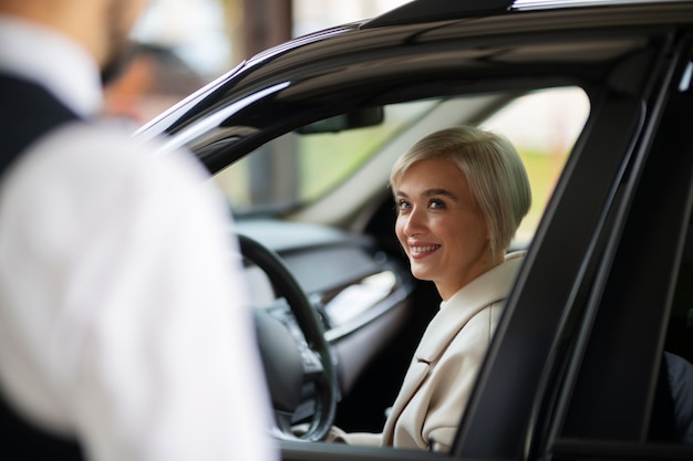 Parcheggiatore che aiuta la donna a parcheggiare la sua auto