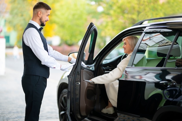 Parcheggiatore che aiuta la donna a parcheggiare la sua auto