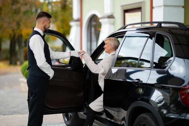 Parcheggiatore che aiuta la donna a parcheggiare la sua auto