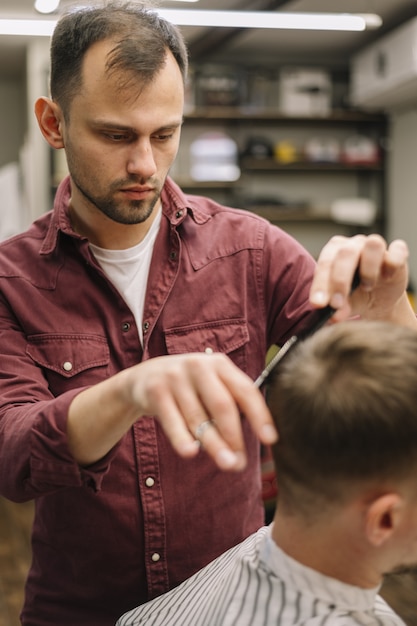 Parrucchiere che dà un taglio di capelli a un cliente