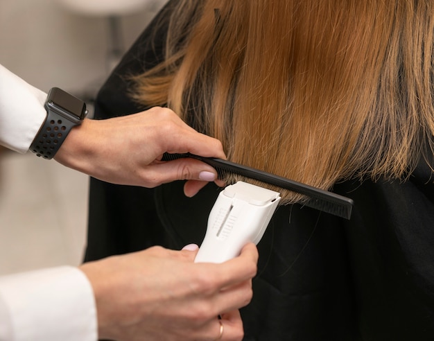 Parrucchiere che disegna i capelli di un cliente al salone