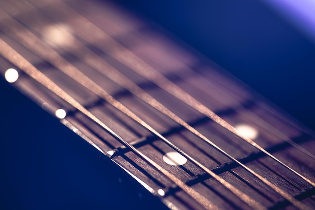 Parte di un fretboard di chitarra acustica su uno sfondo nero