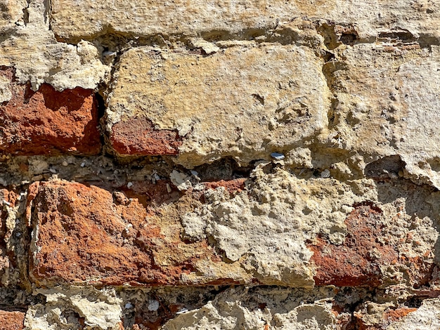 Parte di un vecchio muro di mattoni con mattoni da vicino.