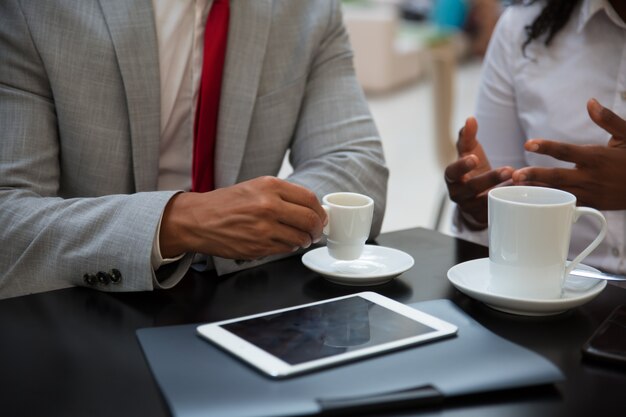 Partner commerciali discutendo questioni di lavoro davanti a una tazza di caffè