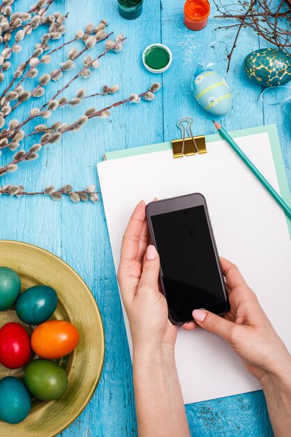 Pasqua nel posto di lavoro d'ufficio sulla tavola di legno blu