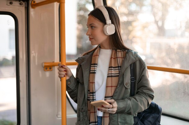 Passeggero femminile che tiene il palo del tram e distoglie lo sguardo