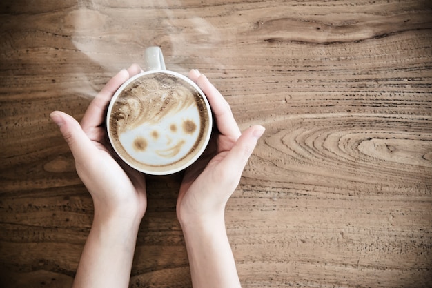 Passi la tenuta della tazza di caffè calda - la gente con il concetto del caffè