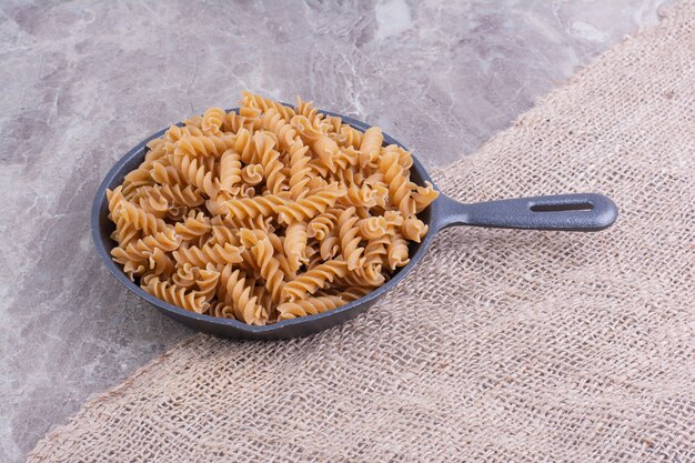 Pasta a forma di spirale in padella di ferro nero