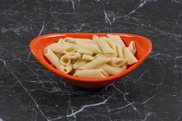 Pasta appena bollita in una ciotola arancione.