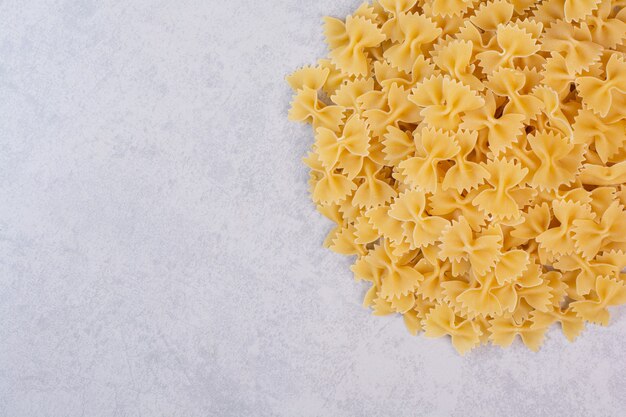 Pasta cruda farfalle su superficie bianca