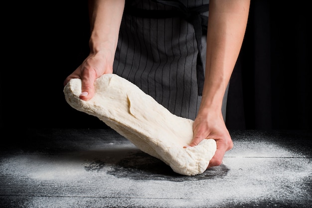 Pasta d'impastamento della donna sulla tavola