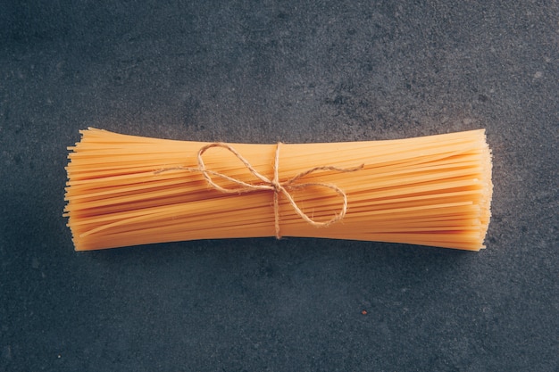 Pasta degli spaghetti di vista superiore su fondo strutturato grigio. orizzontale