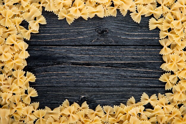 Pasta del farfalle di vista superiore con lo spazio della copia su fondo di legno nero