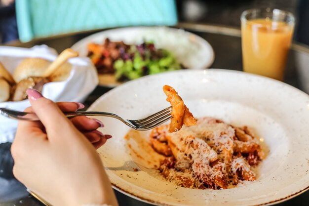 Pasta di penne con la vista laterale della carne delle verdure del parmigiano della salsa al pomodoro