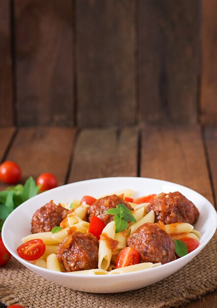 Pasta di penne con polpette in salsa di pomodoro in una ciotola bianca