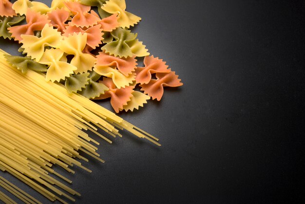 Pasta di spaghetti e farfalle sul bancone della cucina nera