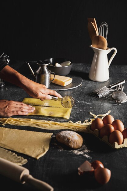 Pasta di taglio della persona del primo piano nella cucina