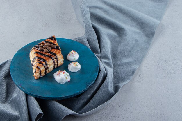 Pasta dolce decorata con cioccolato adagiata su cartoncino blu