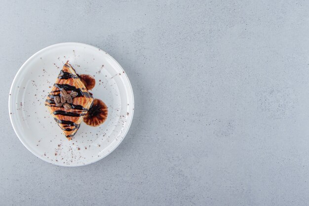 Pasta dolce decorata con cioccolato disposta sul piatto bianco. Foto di alta qualità