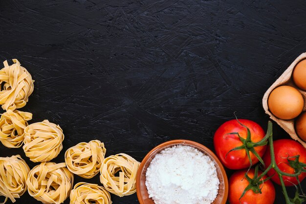 Pasta e farina vicino a pomodori e uova