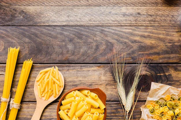 Pasta e grano sul ripiano del tavolo in legno